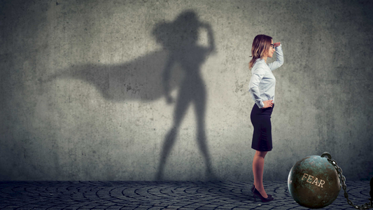 A woman in a pencil skirt gazes into the distance while her shadow on the wall reveals her as Superwoman, symbolizing the hidden strength within every writer