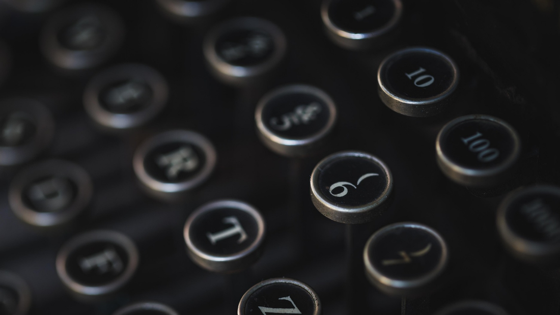 An old-fashioned typewriter keyboard in darkness, symbolizing the immersive and sometimes uncertain process of writing into the dark